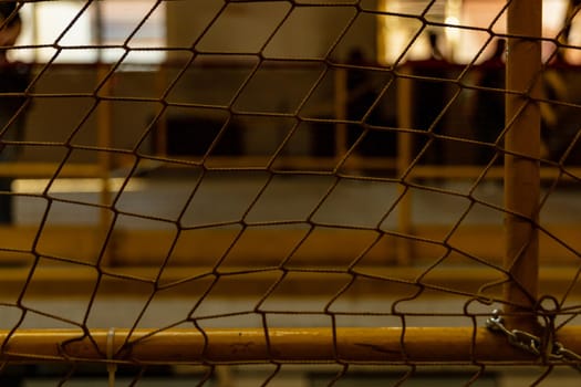 Yellow net in front of big hall with metal yellow railings