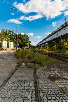 Long rails at old unused factory square next to long bridge