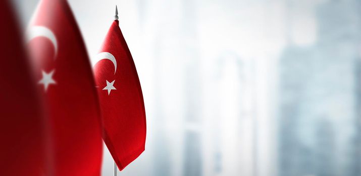 Small flags of Turkey on a blurry background of the city.