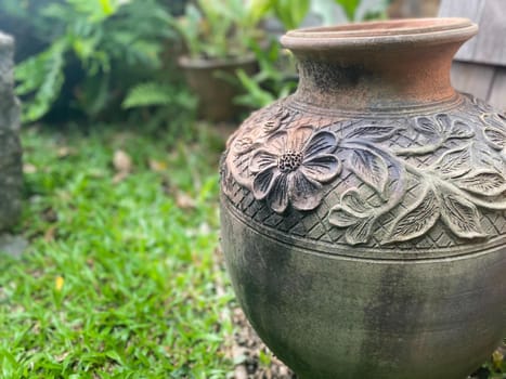 Big earthen jar, Water bowl or jar made from clay covered with moss naturally occurring in a moist and shady atmosphere put decorations in the garden