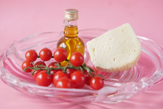 cherry tomato, cheese and olive oil on table .