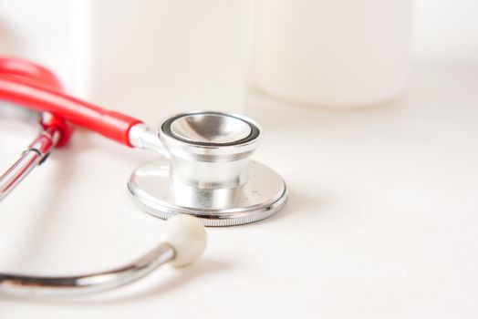 selective focus. stethoscope and pills container on wooden background