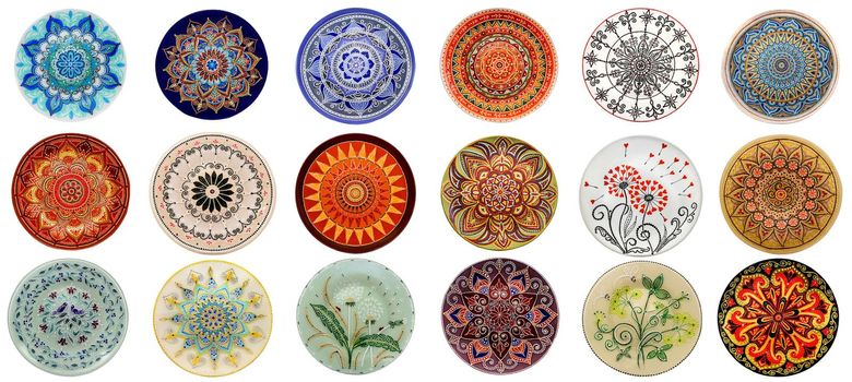 Set of decorative ceramic dishes hand-painted with acrylic paints floral pattern isolated on white background.