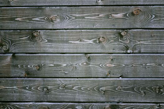 Natural background from gray wooden planks with a pattern of tree rings and twigs.