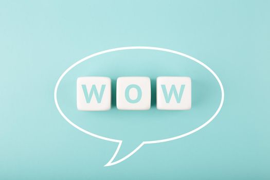 White speech bubble with wow inscription on bright tiffany blue background. Colored elegant and minimal style wow concept of expressing emotions and being excited