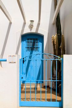Typical Andalusian whitewashed facade with blue painted window and bench