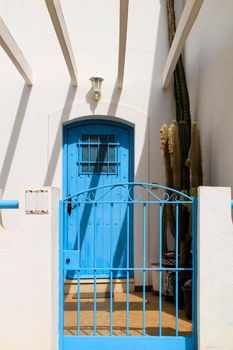 Typical Andalusian whitewashed facade with blue painted window and bench