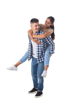 Laughing teen playful couple piggyback ride isolated white background