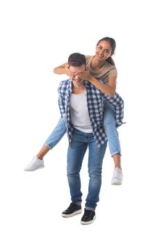 Laughing teen playful couple piggyback ride isolated white background
