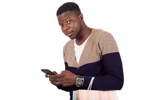 man in gray blue sweater with shopping bags talking on smart-phone isolated on white background