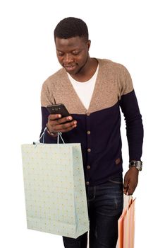 man in gray blue sweater with shopping bags talking on smart -phone isolated on white background