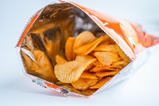 Potato chips, delicious BBQ seasoning spicy for crips, thin slice deep fried snack fast food in open bag.