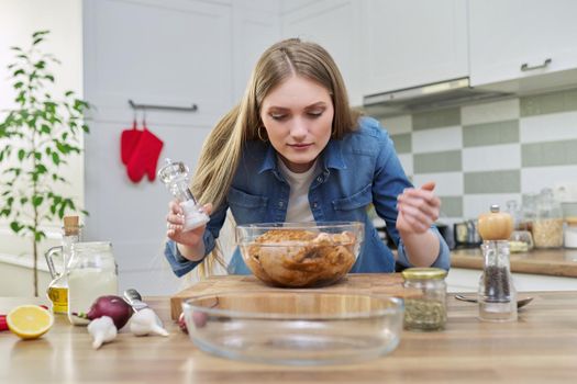 Chicken cooking process, recipe, food blog, food for the holiday. Young woman in the home kitchen preparing meat, chicken