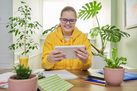 School online learning, e-education, teenage girl looking at screen of digital tablet, video lesson, homework.