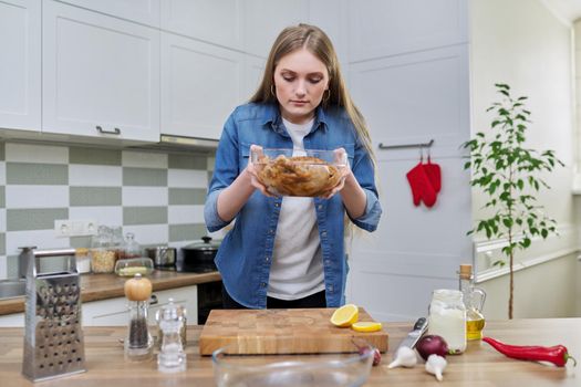 Chicken cooking process, recipe, food blog, food for the holiday. Young woman in the home kitchen preparing meat, chicken