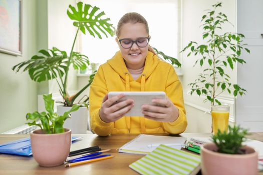 School online learning, e-education, teenage girl looking at screen of digital tablet, video lesson, homework.