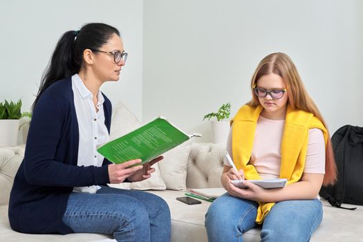 Female teacher studying individually with teenage girl, instructor testing young student