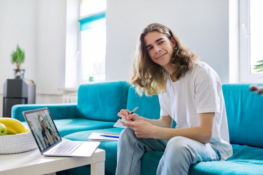 Individual online lesson, teenage boy sitting at home with laptop, studying using remote video consultation, female teacher mentor on computer screen. E-education, technology in teaching, adolescence