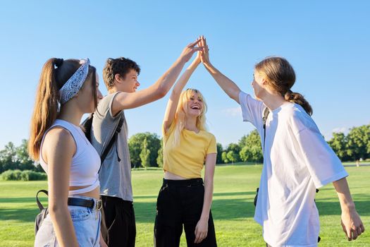 Meeting of teenage friends. Group of cheerful happy teenagers walking along road on sunny summer day. Adolescence, youth, friendship, young people concept