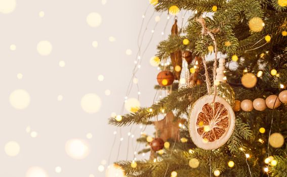 Christmas tree decorated in scandinavian style, rustic ornament and defocused lights. Stock photo with copy space.