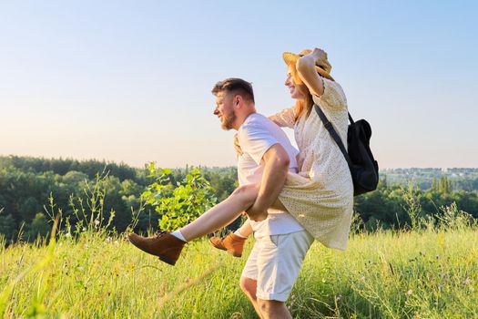 Happy laughing adult couple having fun outdoors, nature sky background. People 30s 40s age, relationships, dating, family, happiness, love, lifestyle concept