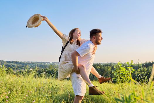 Happy laughing adult couple having fun outdoors, nature sky background. People 30s 40s age, relationships, dating, family, happiness, love, lifestyle concept