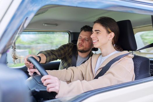 Father teaching his teenage son to drive. Family, relationship middle aged parent teenager, friendship of father and son