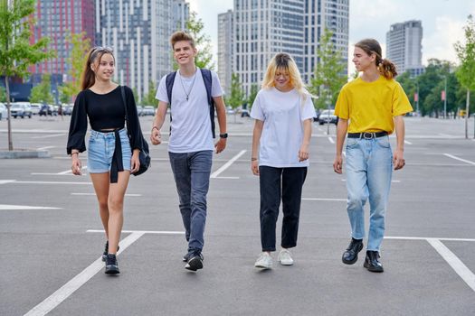 Group of teenagers walking together, urban style, modern city background. Happy smiling youth, lifestyle, friendship, high school, college, adolescence concept