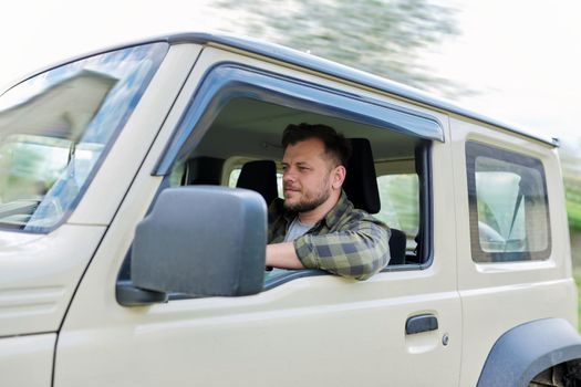 Handsome middle-aged man, driver driving car, looking forward at road.