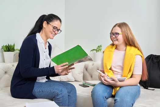 Female teacher studying individually with teenage girl, instructor testing young student