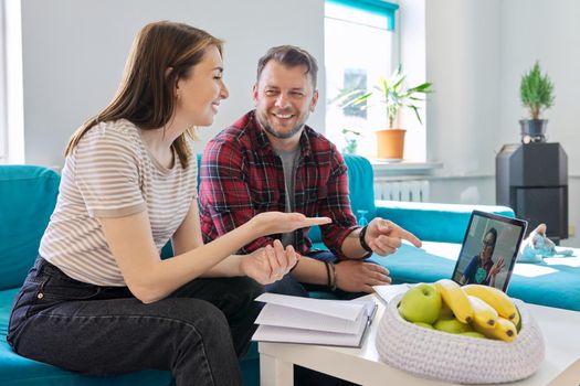 Happy middle-aged couple at an online meeting with doctor, happy man and woman, good news, telemedicine, teletechnology in medicine