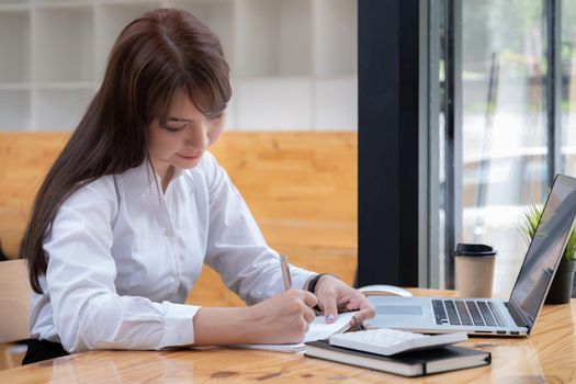 Young undergraduate student studying online class by laptop computer.