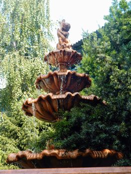 Beautiful decorative bronze fountain in the garden. High quality photo