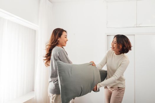 Beautiful sexy two girls having fun in bedroom, pillow fight.