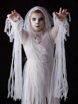 Little girl in Halloween ghost costume walking on you, studio isolated on black background