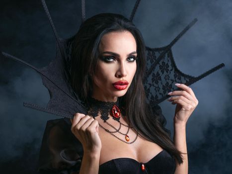 Vampire Halloween woman portrait. Beautiful sexy model girl in Halloween costume and make up