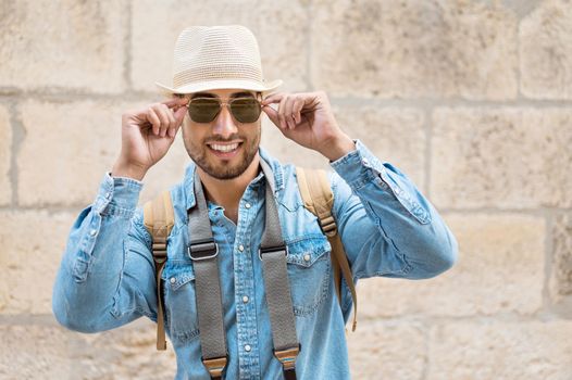 Stylish traveler bearded man in hat posing looking at camera, travel and wanderlust concept. High quality photo