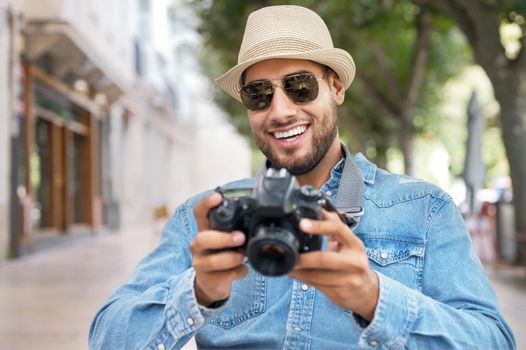 Handsome tourist checking photos in digital camera. High quality photo.