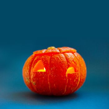 Halloween pumpkin on blue background unusual composition background with copy space for text