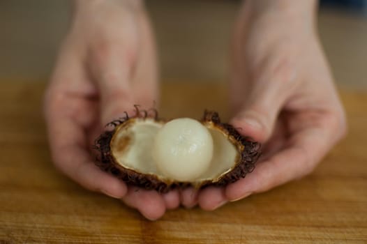 Ripe rambutan and leechy or lychee fruits on wooden table. Healthy food, fresh organic fruit