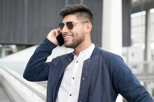 Handsome Man talking on cellphone at modern office building. High quality photo