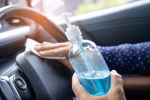 New Normal, Asian working woman clean in car by press blue alcohol sanitizer gel for protect safety Coronavirus.