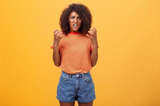 Woman going out of control feeling sick and tired ready to show rage and fury. Portrait of pissed and annoyed furious female clenching raised fists frowning and frimacing looking with scorn and hate. Negative emotions concept