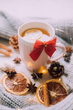 New Year's tea with a garland and oranges . Christmas mood. A cold evening. Hot drinks. Winter decor