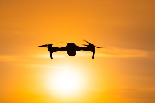 The drone is in flight at sunset . Video shooting from above. An article about the choice of a quadrocopter. Pros and cons of the drone. Sunset