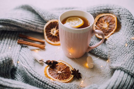 New Year's tea with a garland and oranges . Christmas mood. A cold evening. Hot drinks. Winter decor