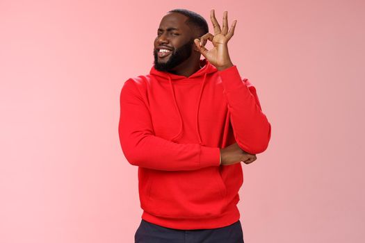 Attractive satisfied happy charismatic handsome male black customer very impressed recommend good quality service show okay ok perfection gesture smiling happily, pink background.