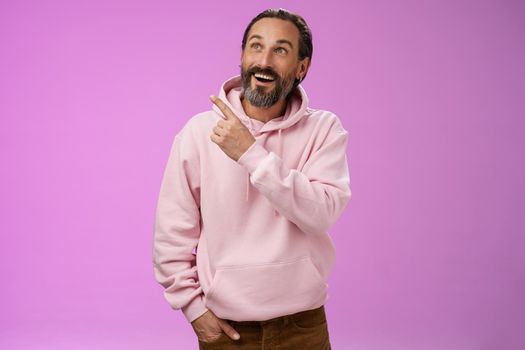 Fascianted joyful handsome mature 40s bearded husband attend interesting amusement park impressed pointing upper left corner enjoying weekend look surprised wondered, gazing alluring product.