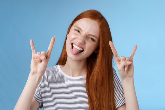 Lifestyle. Daring carefree playful excited good-looking funny redhead girl having fun show tongue squinting do thrilled grimace make rock-n-roll heavy metal sign enjoy awesome party cool concert.