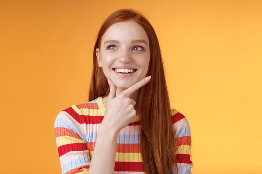 Lifestyle. Creative satisfied smart redhead girl got excellent idea touching chin smiling broadly delighted good thought look upper left corner thinking pondering made up choice wanna implement plan.